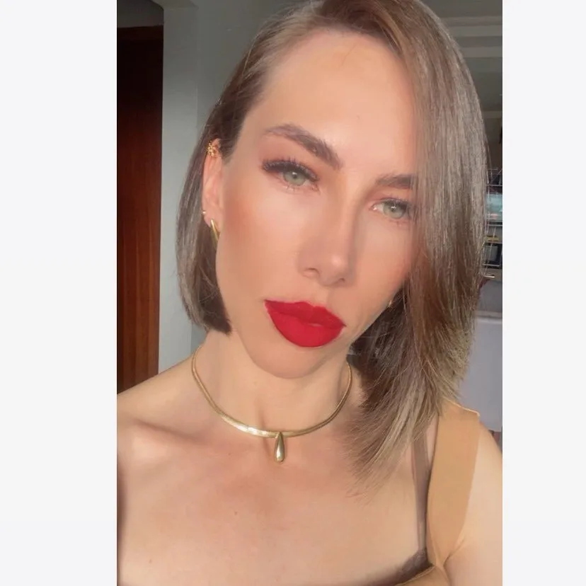 Dra. Cris Barros, de batom vermelho e cabelo na altura dos ombros